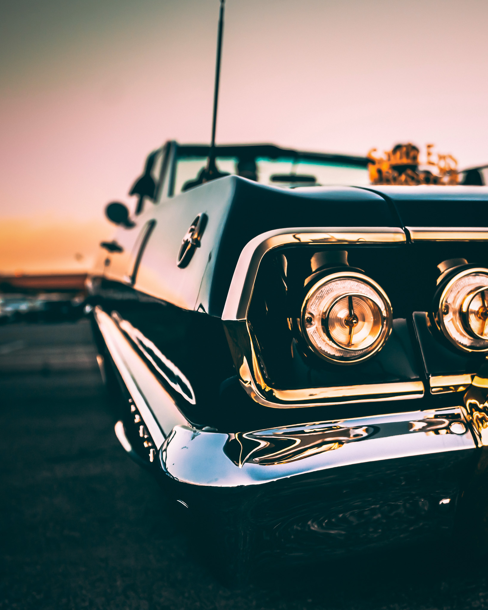 Golden hour headlight detail with warm sunset light on chrome